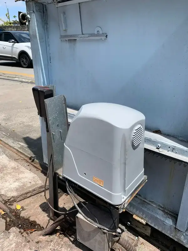 Motor deslizante branco instalado em portão de garagem